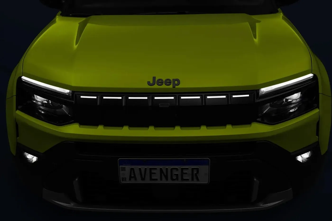 Frente del Jeep Avenger de noche con la firma de luces LED encendida